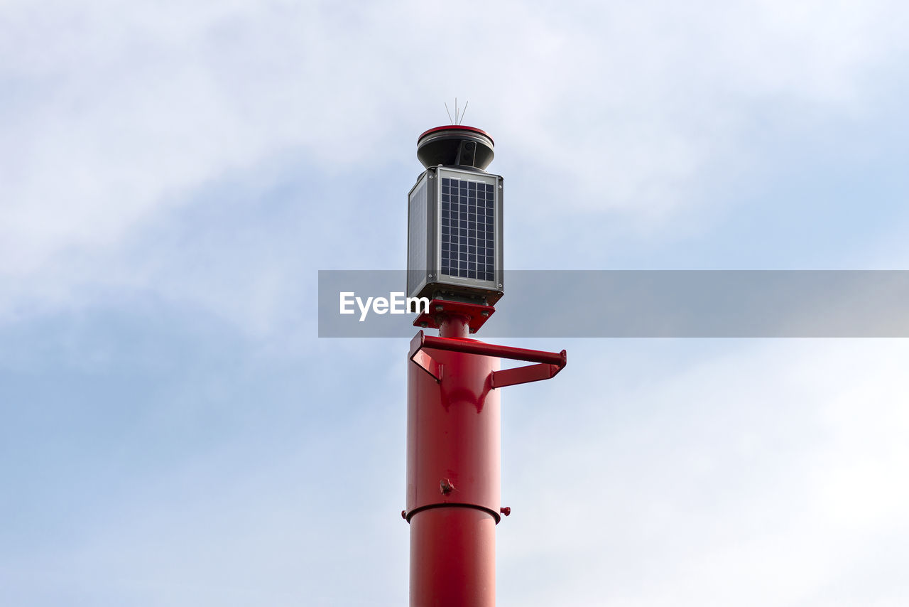 A signal buoy standing on the lake, made of solar panels, mounted on a steel tower.