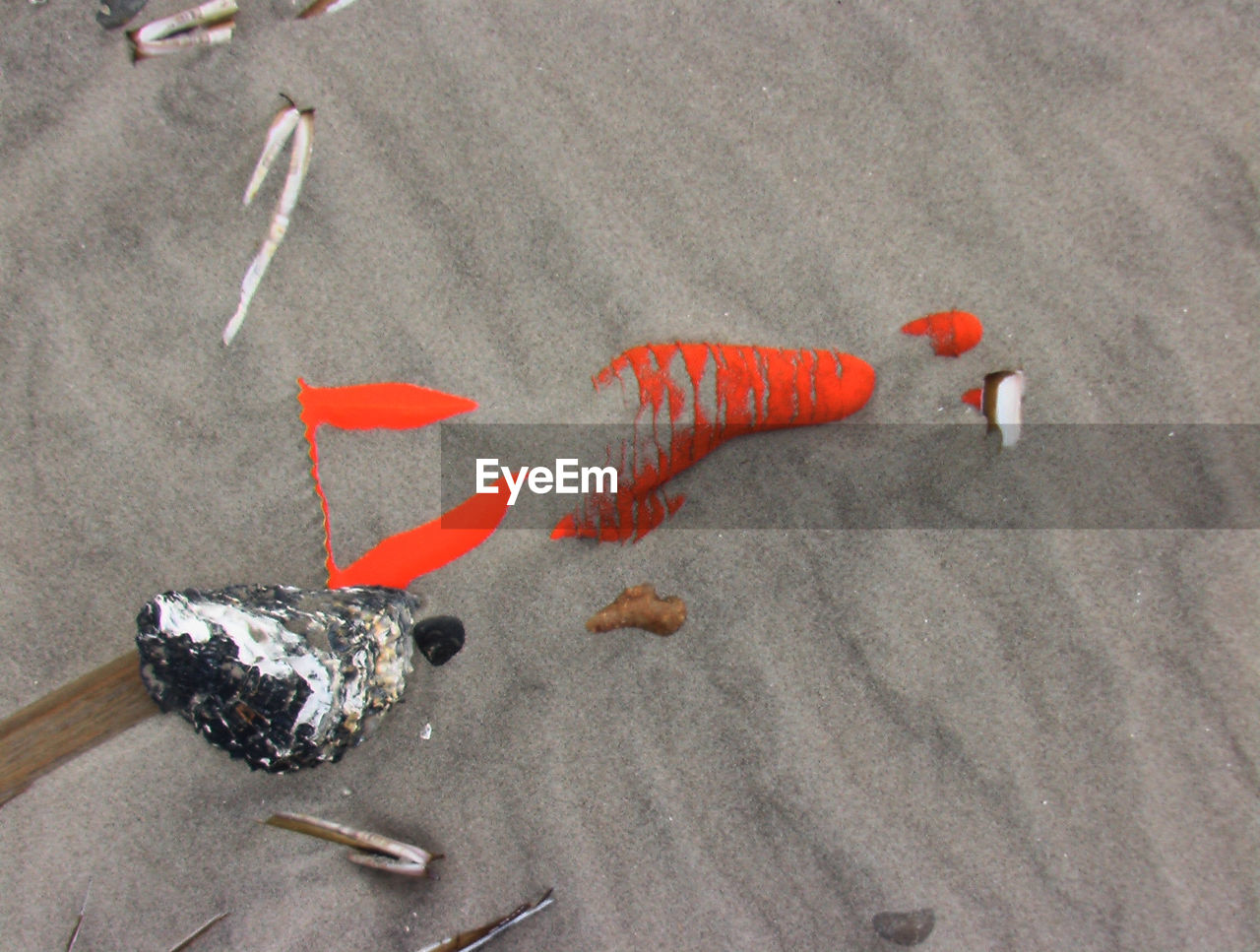 Directly above shot of abandoned orange glove on sandy beach