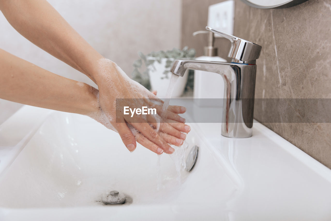 Midsection of woman in bathroom at home