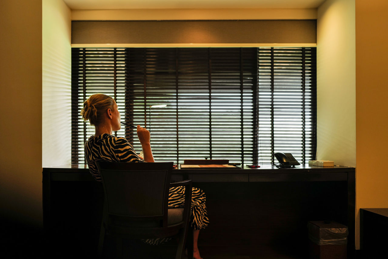 Woman sitting down next to the writing table making notes