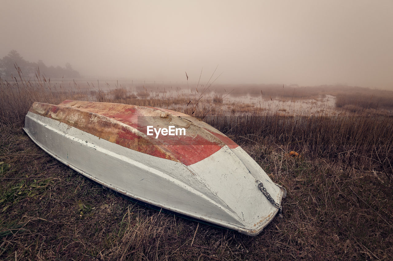 UPSIDE DOWN IMAGE OF ABANDONED CAR ON FIELD