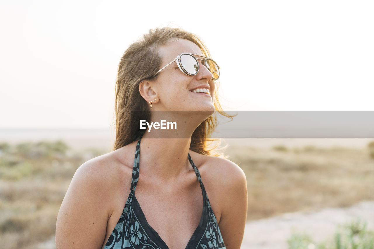 Smiling beautiful woman in sunglasses looking away during vacations