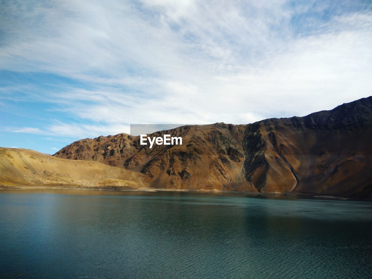 Scenic view of lake by mountains against sky