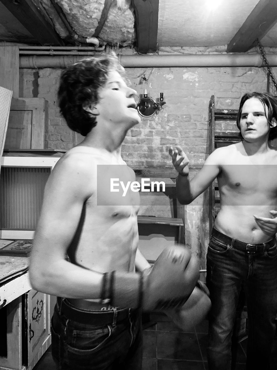 Shirtless men practicing boxing indoors