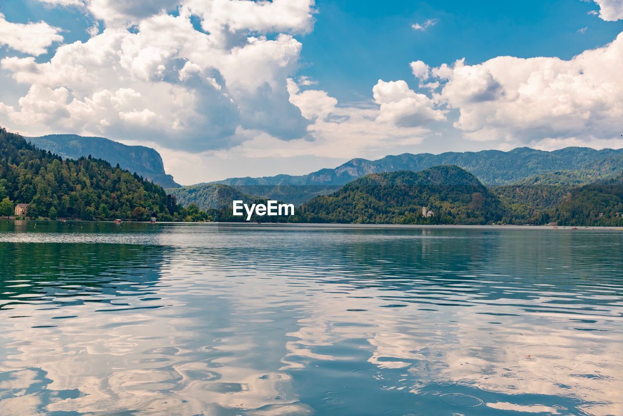 Scenic view of lake by mountains against sky