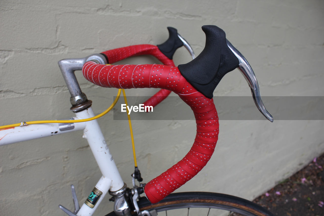 Close-up of bicycle handlebar against the wall