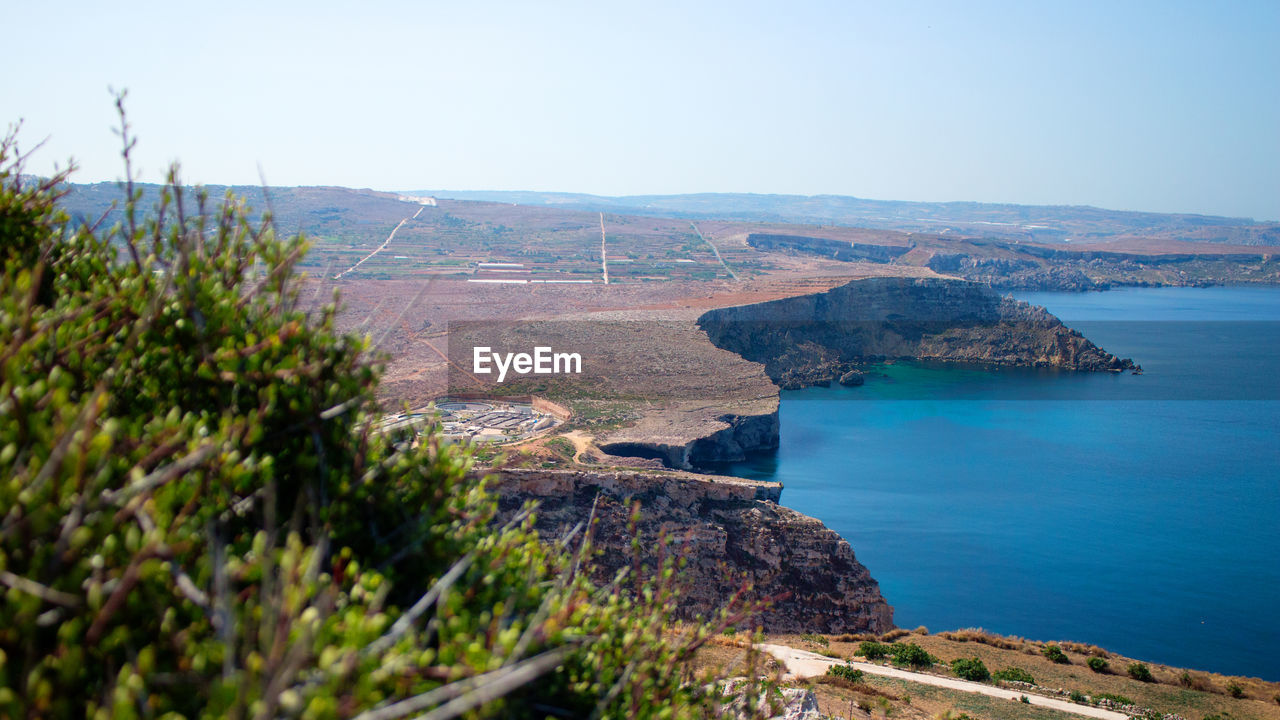 Scenic view of sea and mountains against clear sky