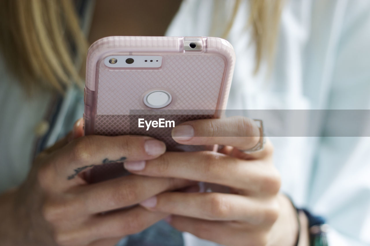 CLOSE-UP OF WOMAN USING MOBILE PHONE IN LAPTOP