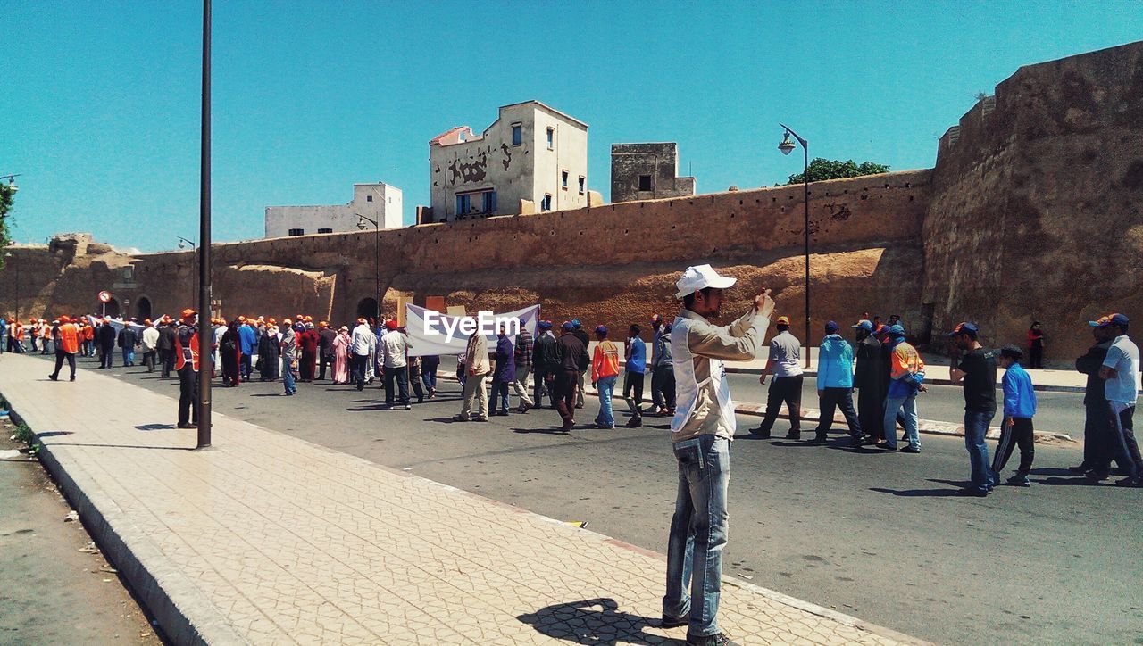 PEOPLE IN TOWN SQUARE AGAINST SKY