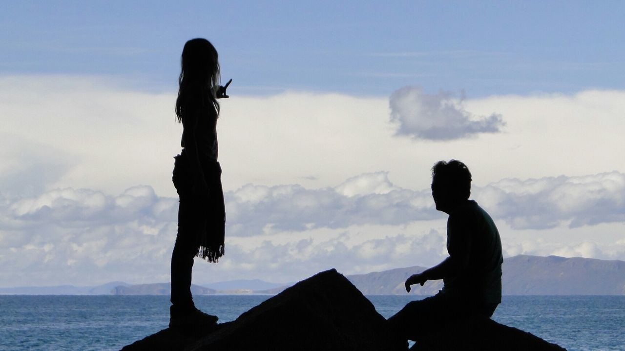 SILHOUETTE OF WOMAN JUMPING ON BEACH