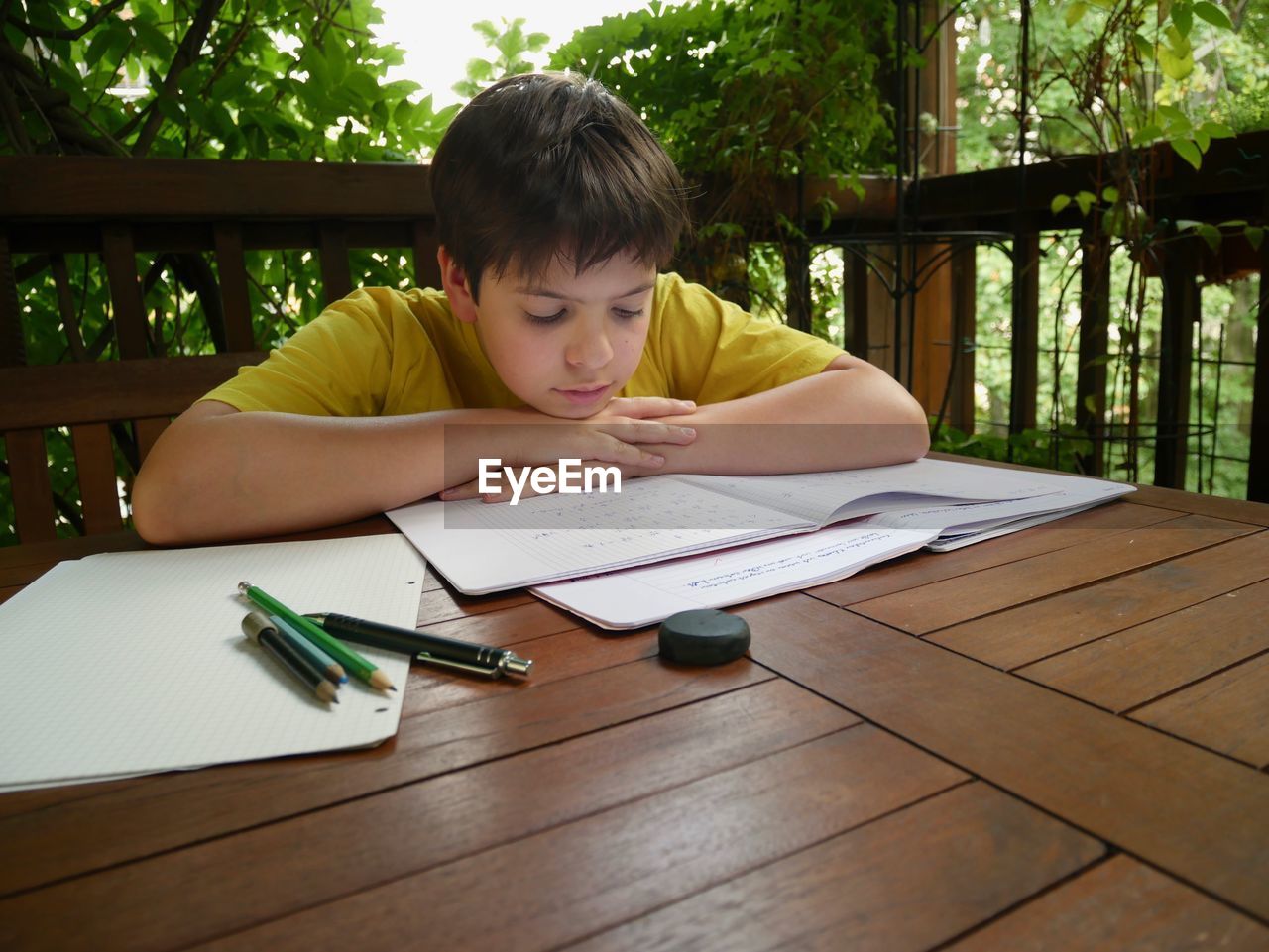 Boy studying at table in porch