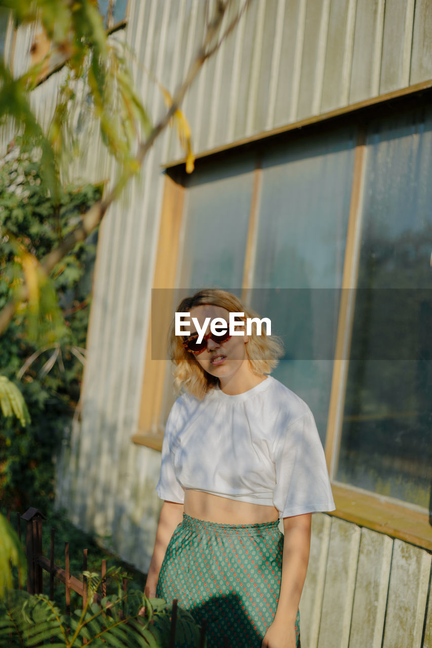 Portrait of beautiful woman standing by window