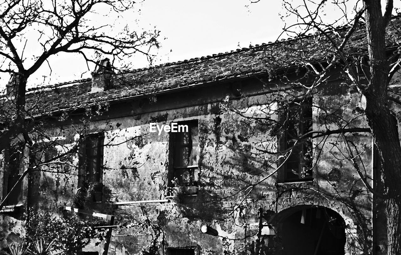 OLD BUILDING WITH TREES IN BACKGROUND