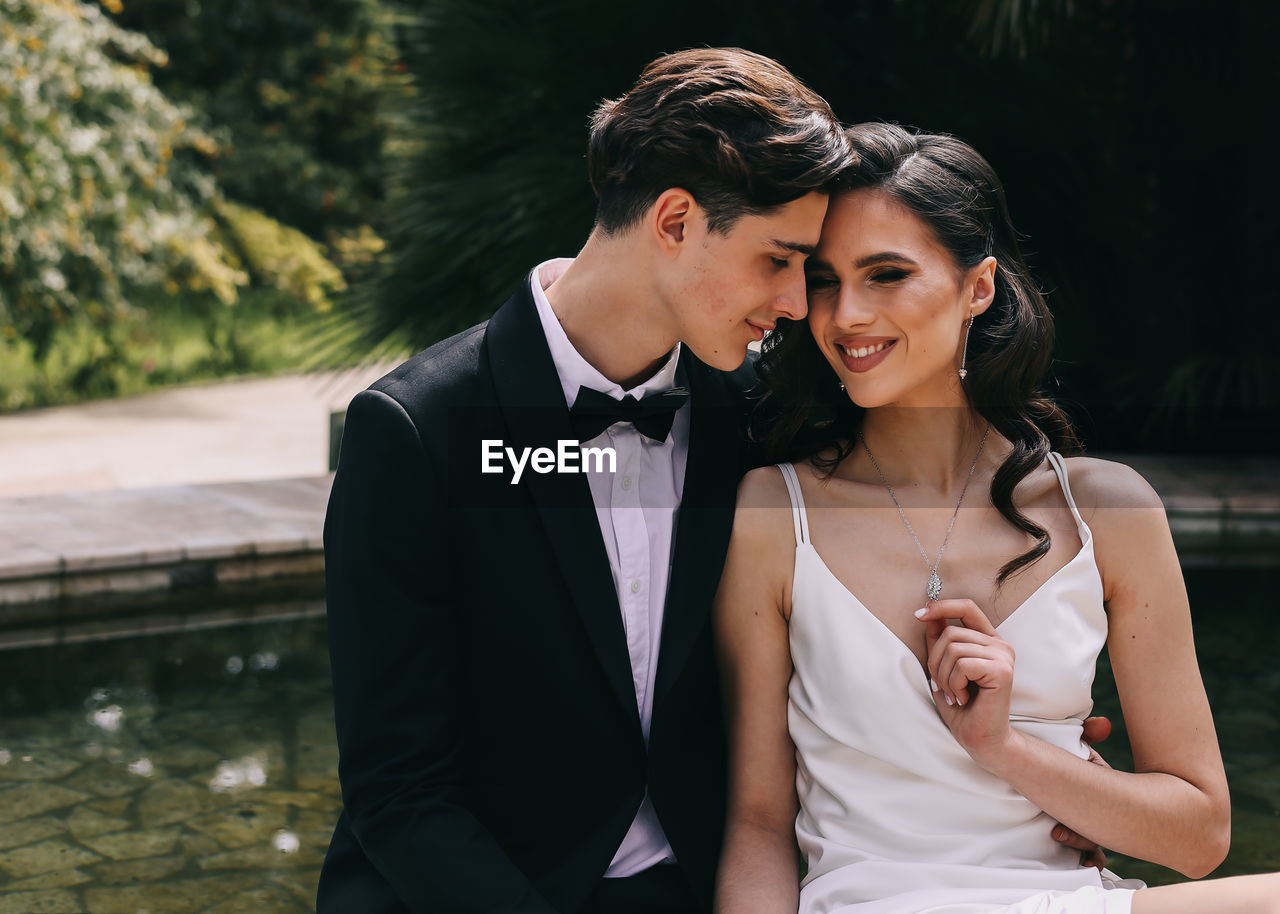 A beautiful couple in love, bride and groom in wedding clothes, walk and pose in the park in nature