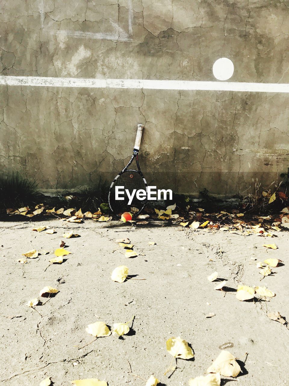 High angle view of racket with ball on field against wall