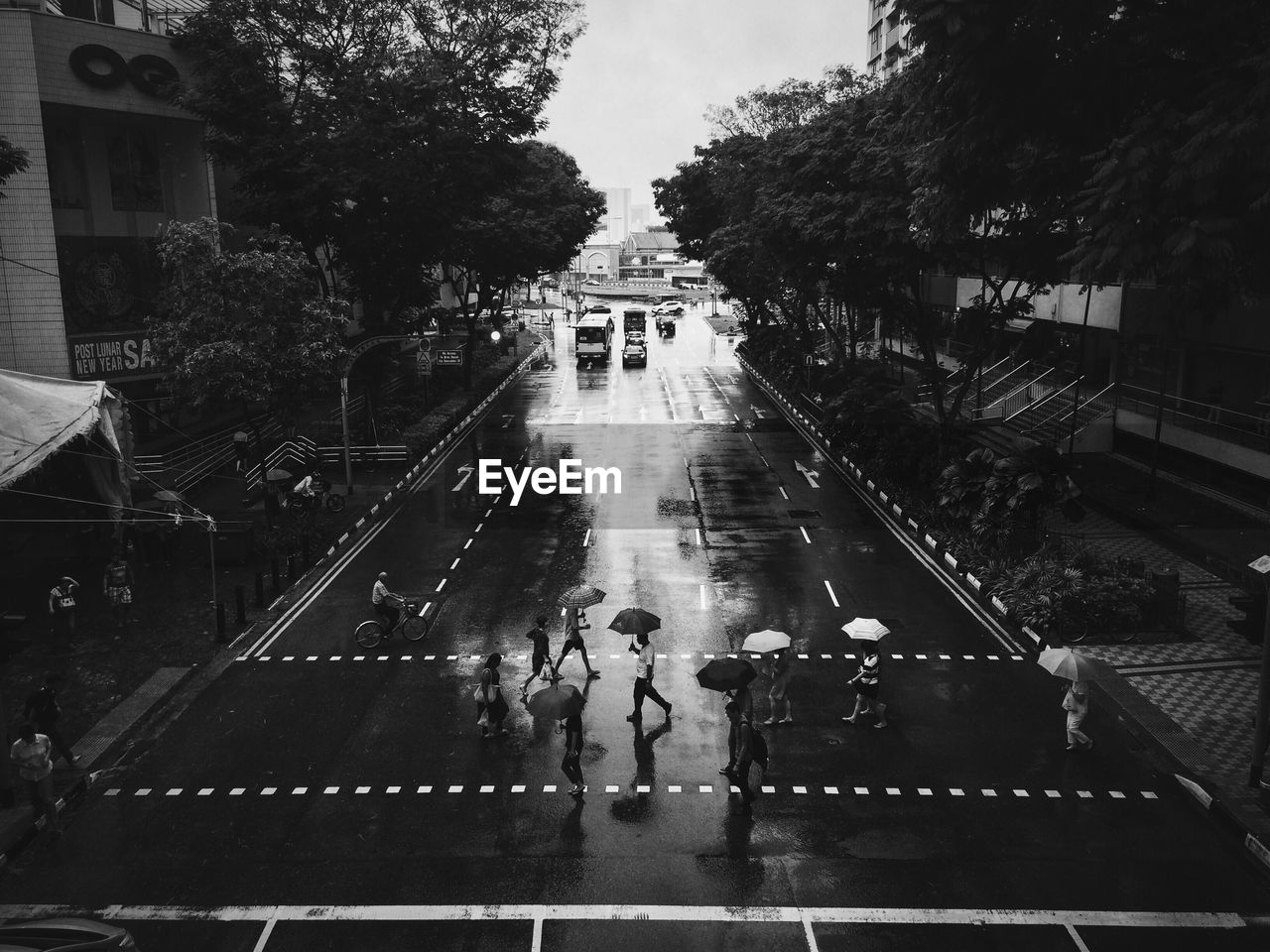 HIGH ANGLE VIEW OF PEOPLE WALKING ON WET ROAD IN RAIN