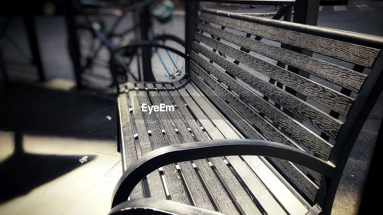 CLOSE-UP OF EMPTY PARK BENCH