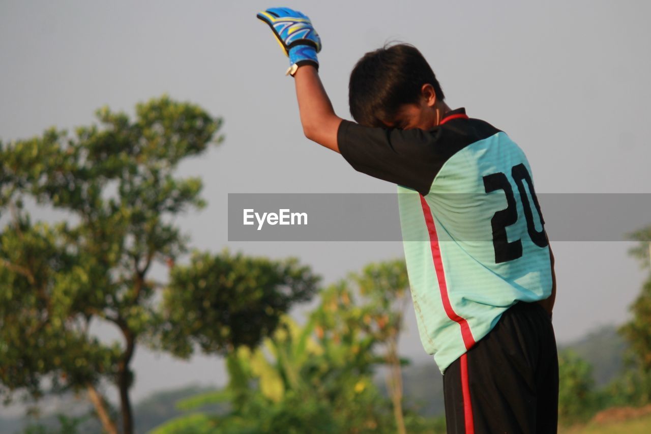 Man in sports clothing standing against sky