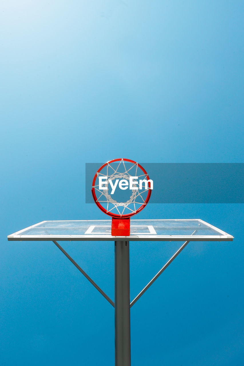 Low angle view of basketball hoop against blue sky