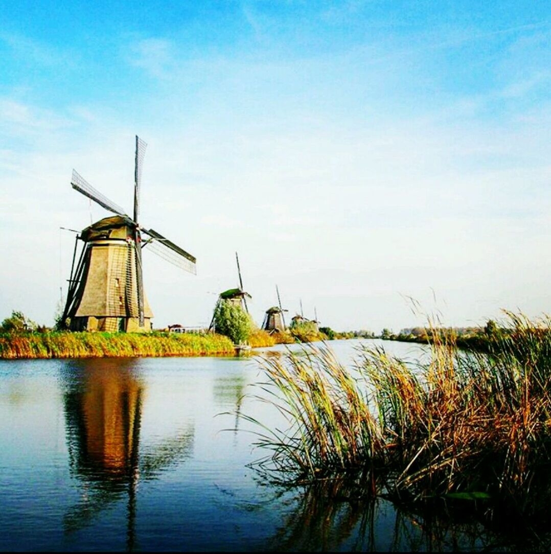 TRADITIONAL WINDMILL IN FARM AGAINST SKY