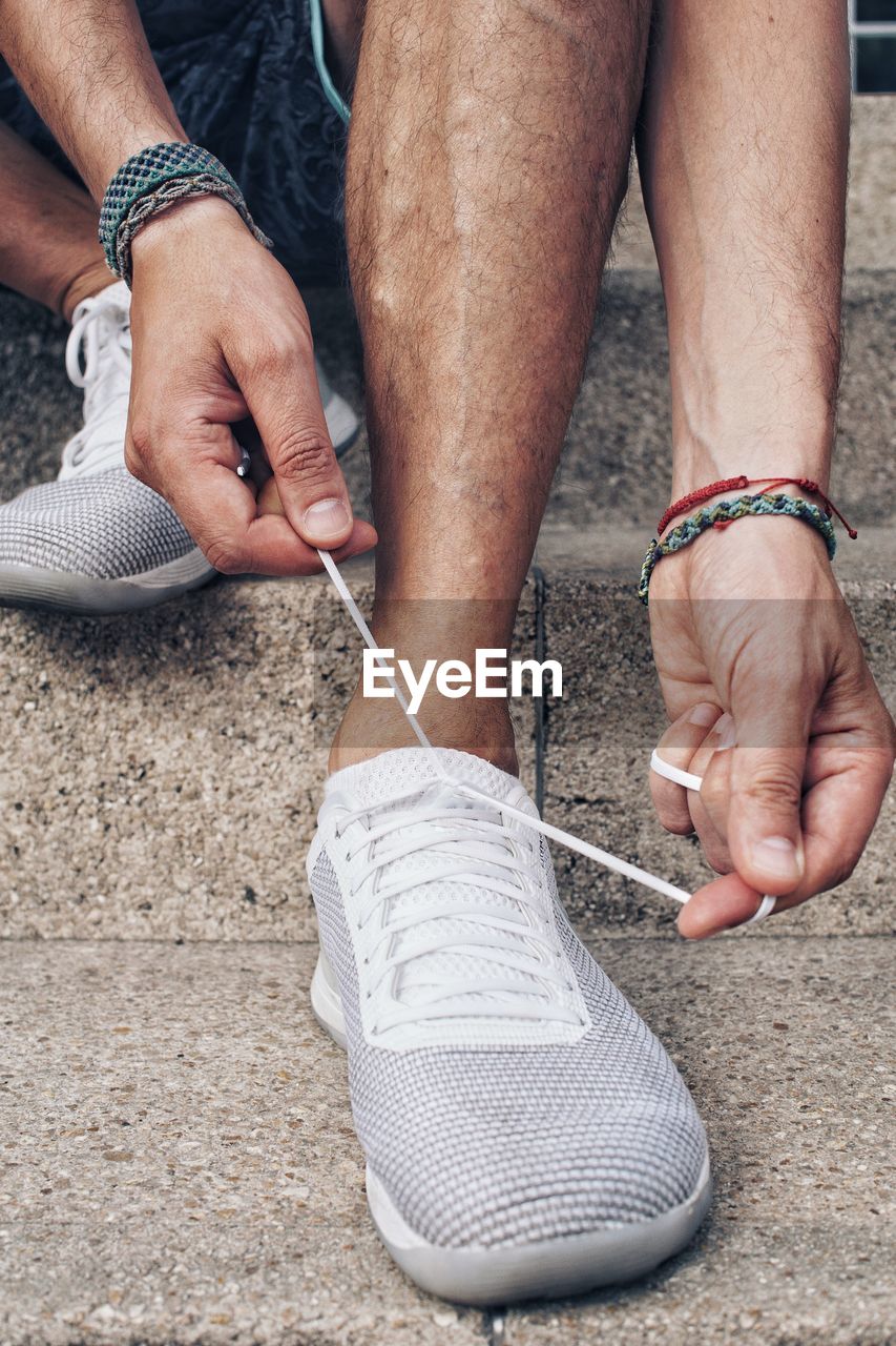 Low section of man tying shoe on steps