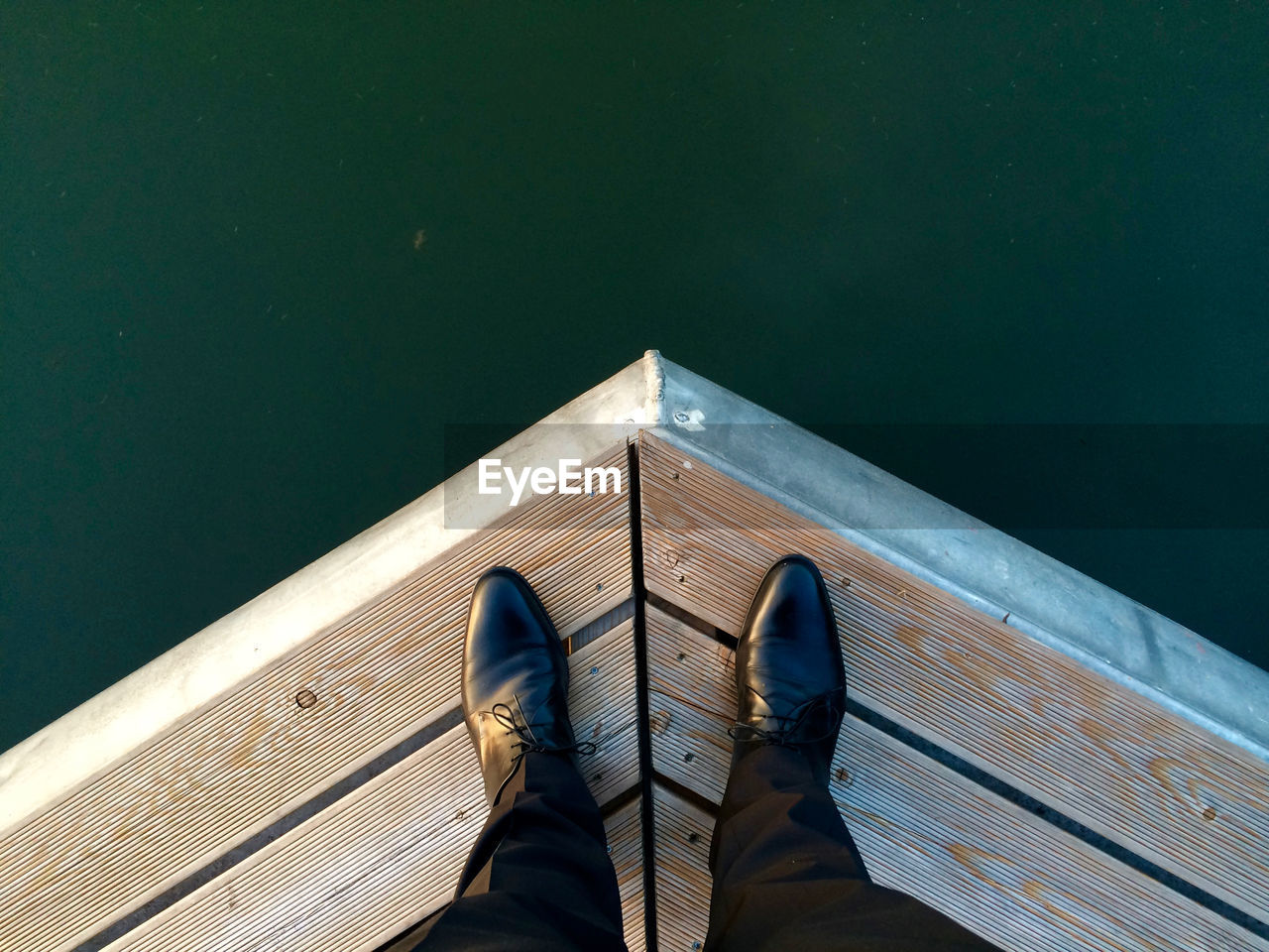 Low section of woman standing in front of lake