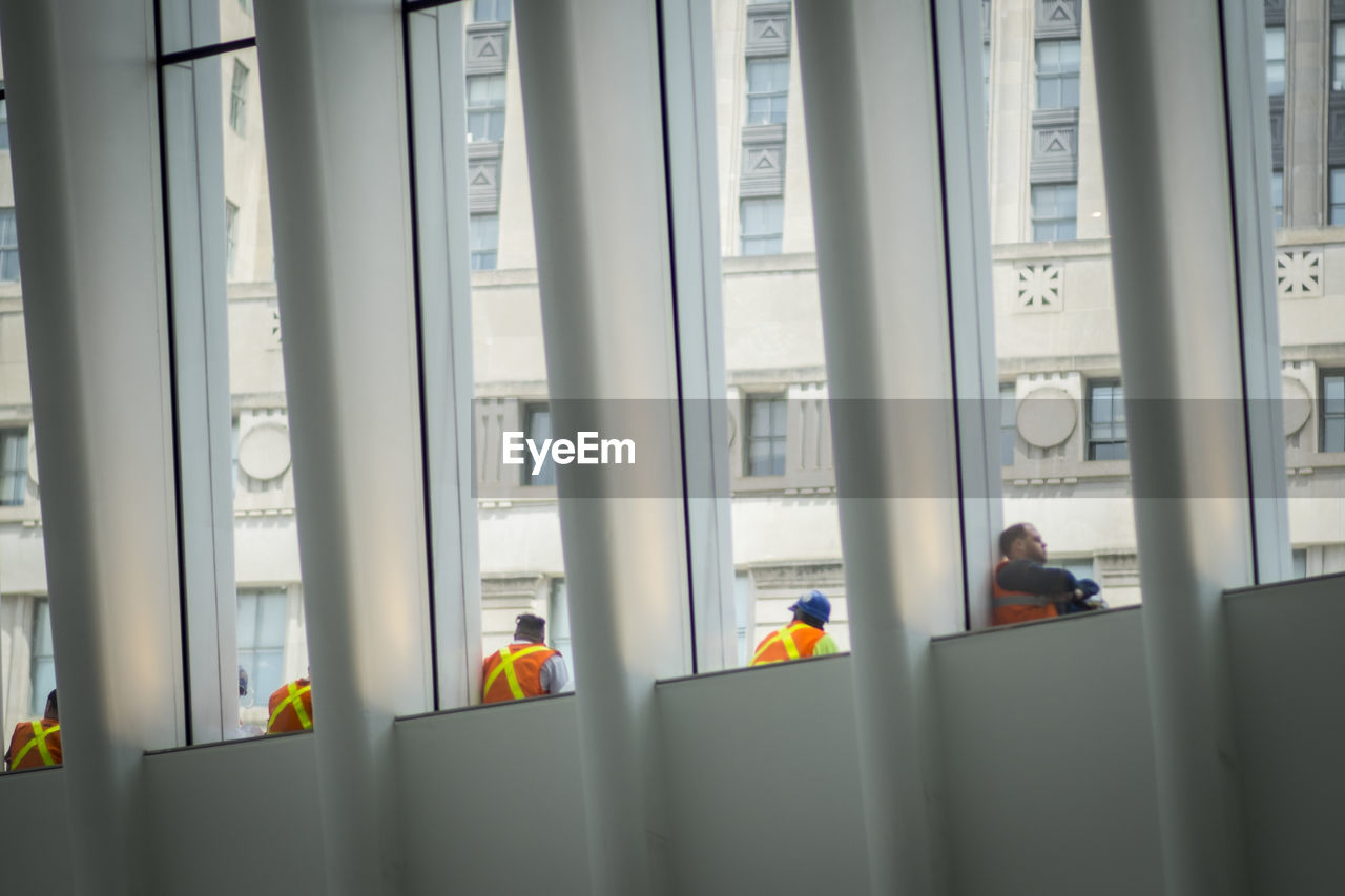 REAR VIEW OF PEOPLE STANDING IN BUILDING