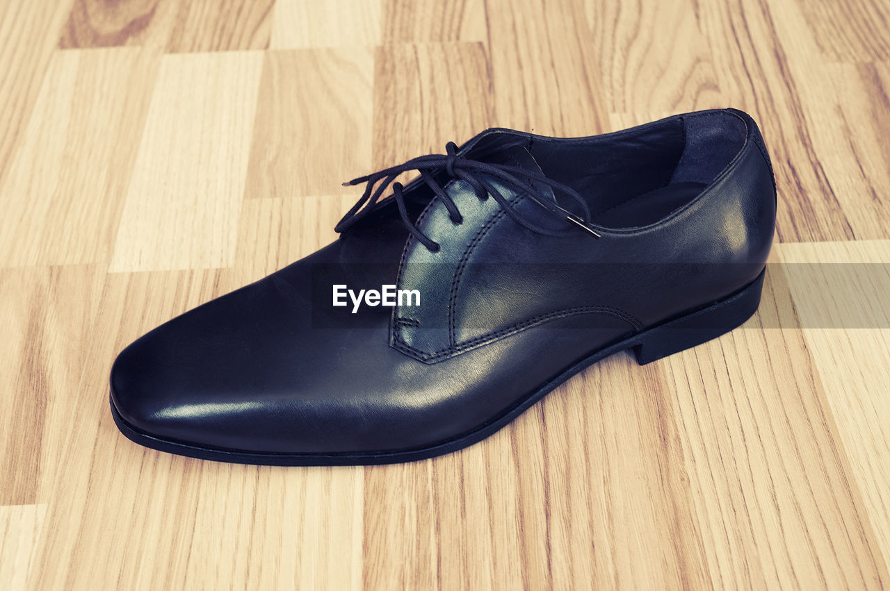 Close-up of leather shoe on hardwood floor