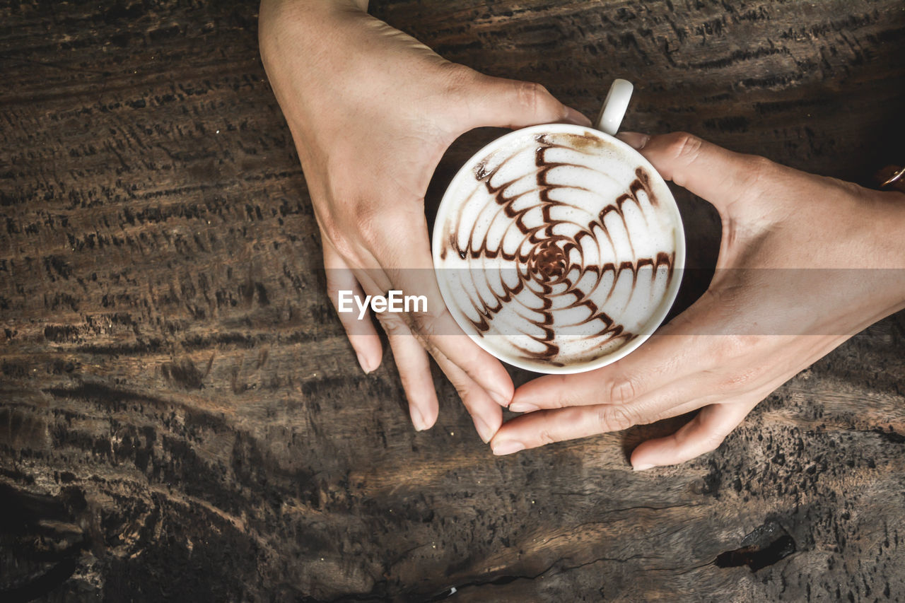 High angle view of hands holding hot chocolate