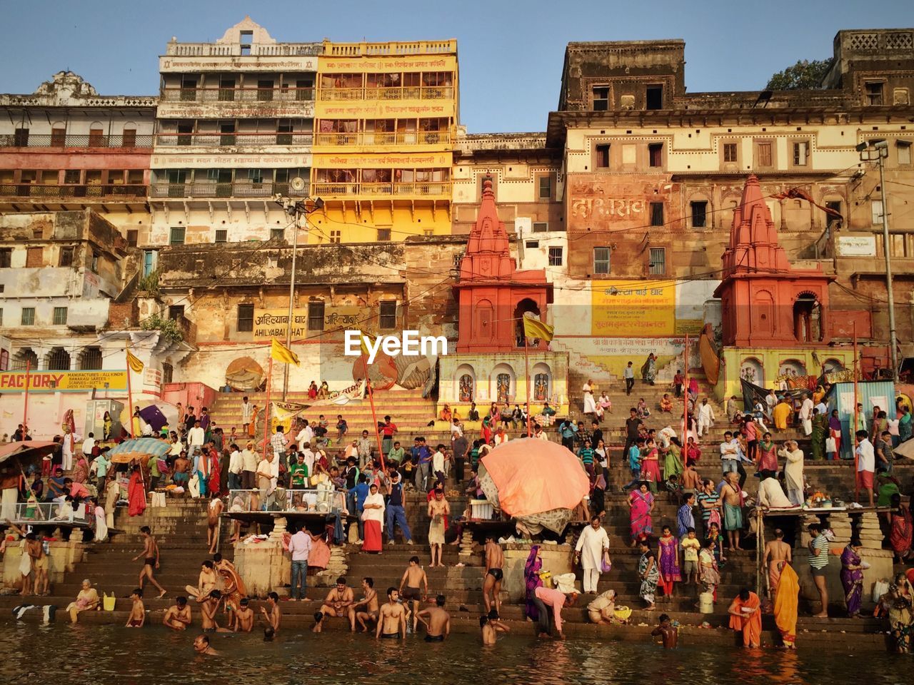 People by ganges river against building