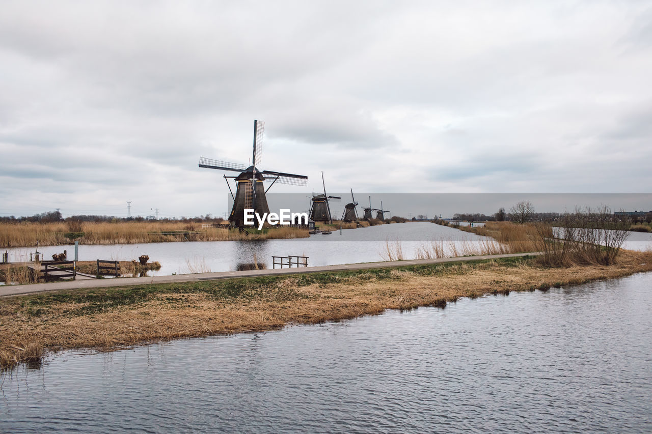 TRADITIONAL WINDMILL ON RIVER AGAINST SKY