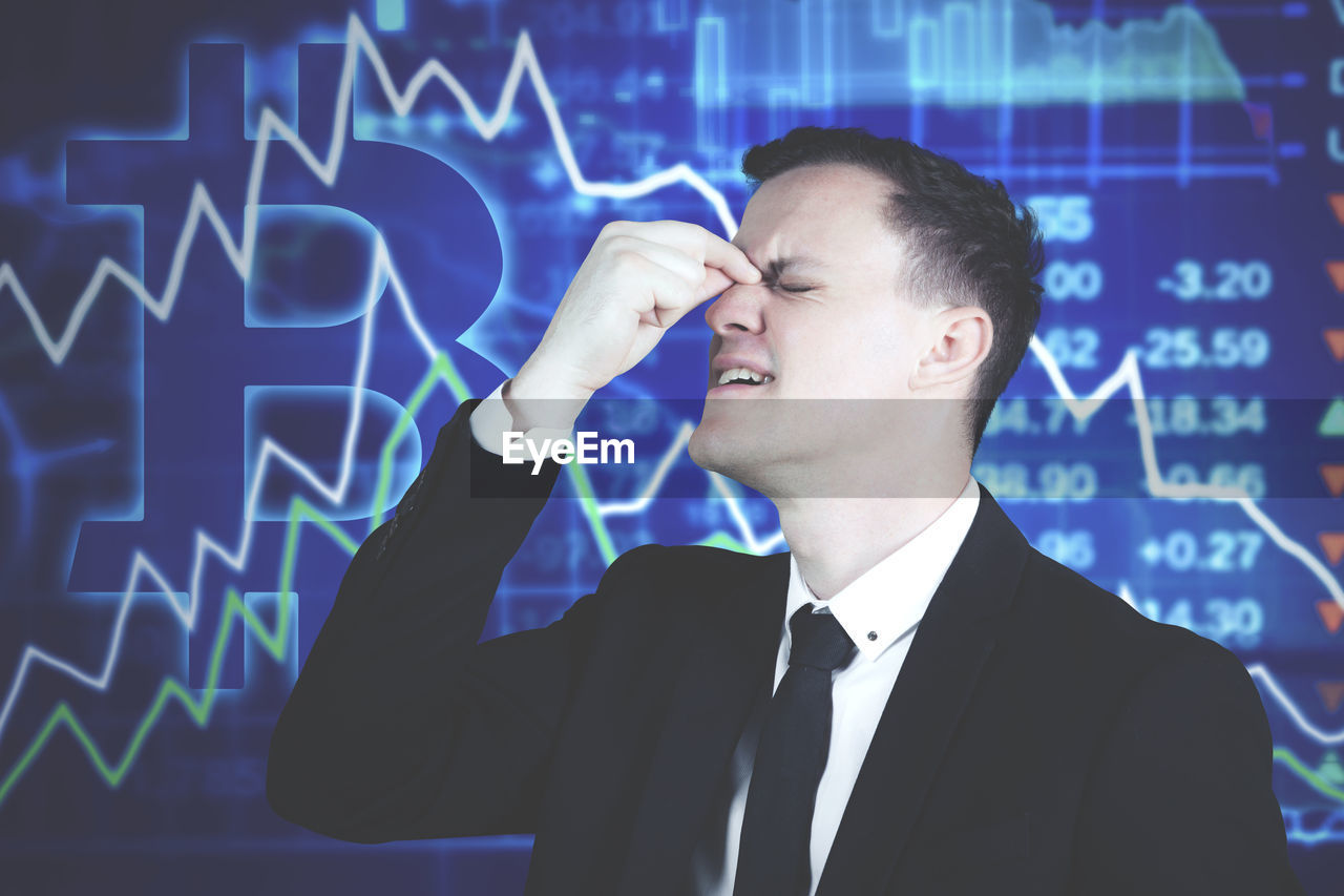 Digital composite image of businessman against symbols