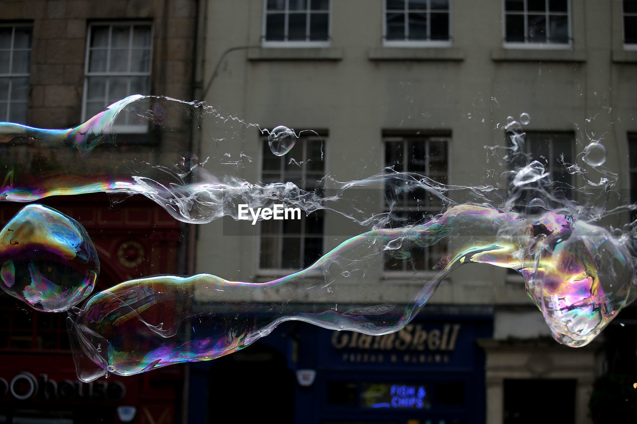 MULTI COLORED BUBBLES AGAINST BUILDINGS