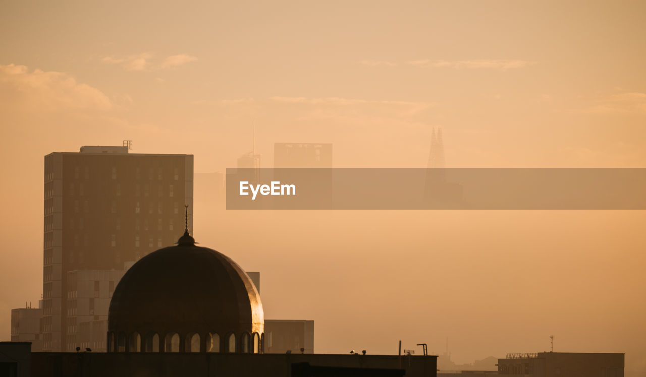 Silhouette buildings against sky during sunset in city