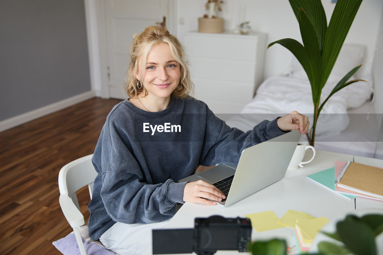 portrait of young woman using digital tablet while sitting at home