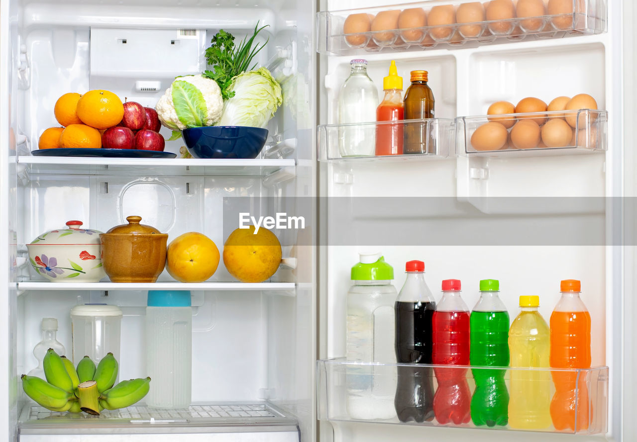 Look into the refrigerator with the lid open a lots of fresh food and drinks inside.