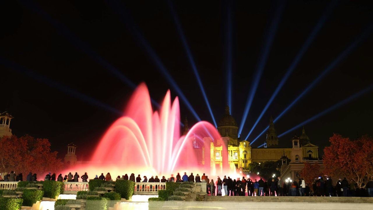 People watching illuminated fountain at night