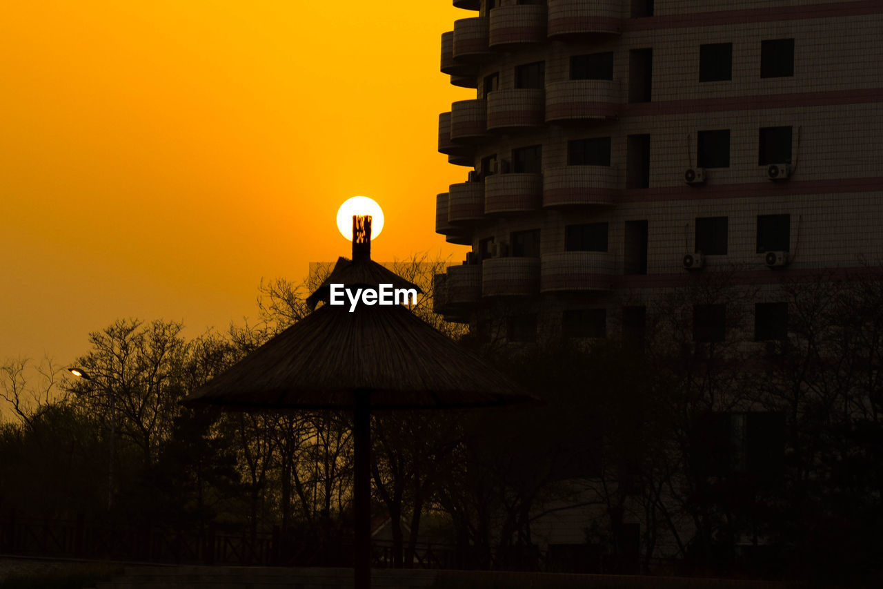 Silhouette of building against sky during sunset