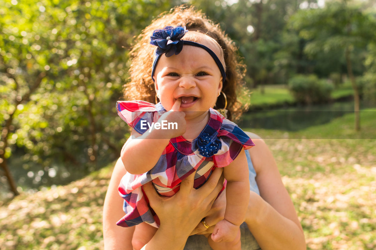 Portrait o smiling girl with mother outdoors