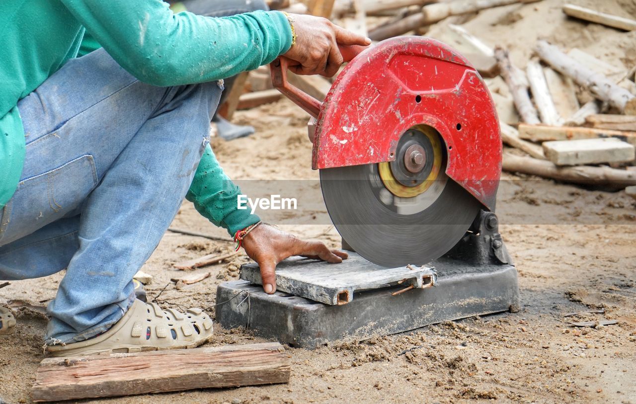 Low section of man cutting metal