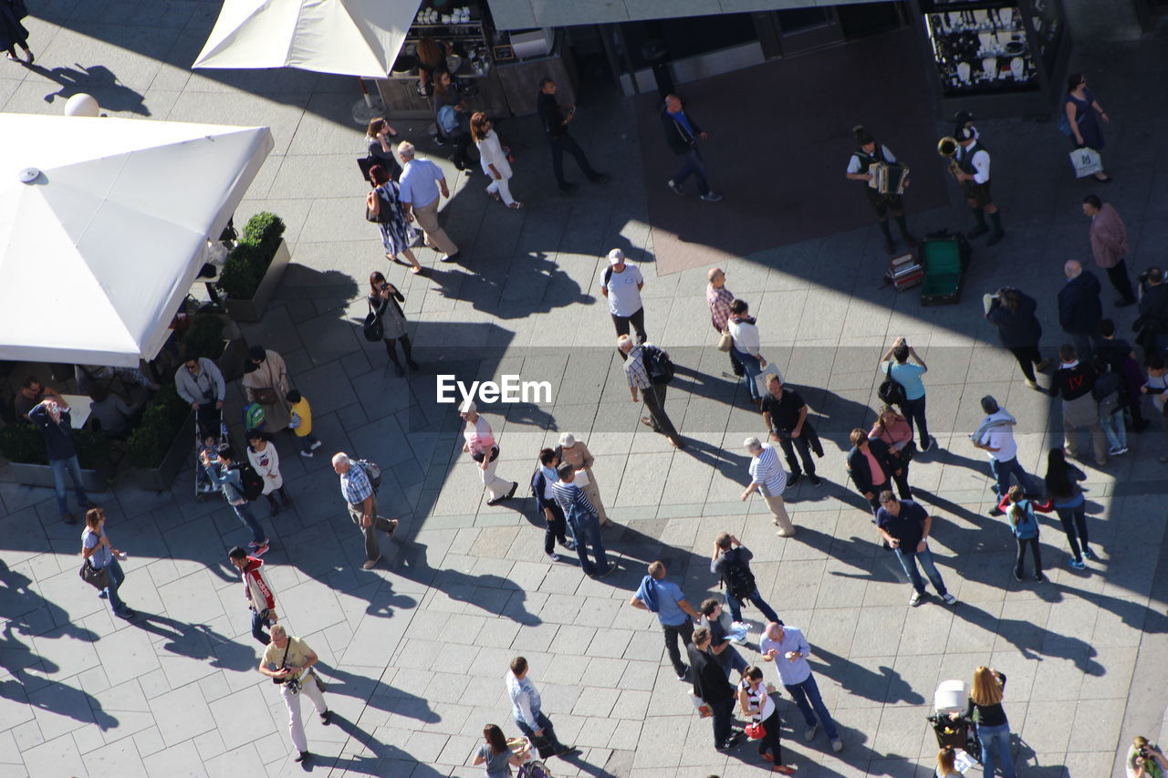 HIGH ANGLE VIEW OF PEOPLE WALKING ON STREET IN CITY