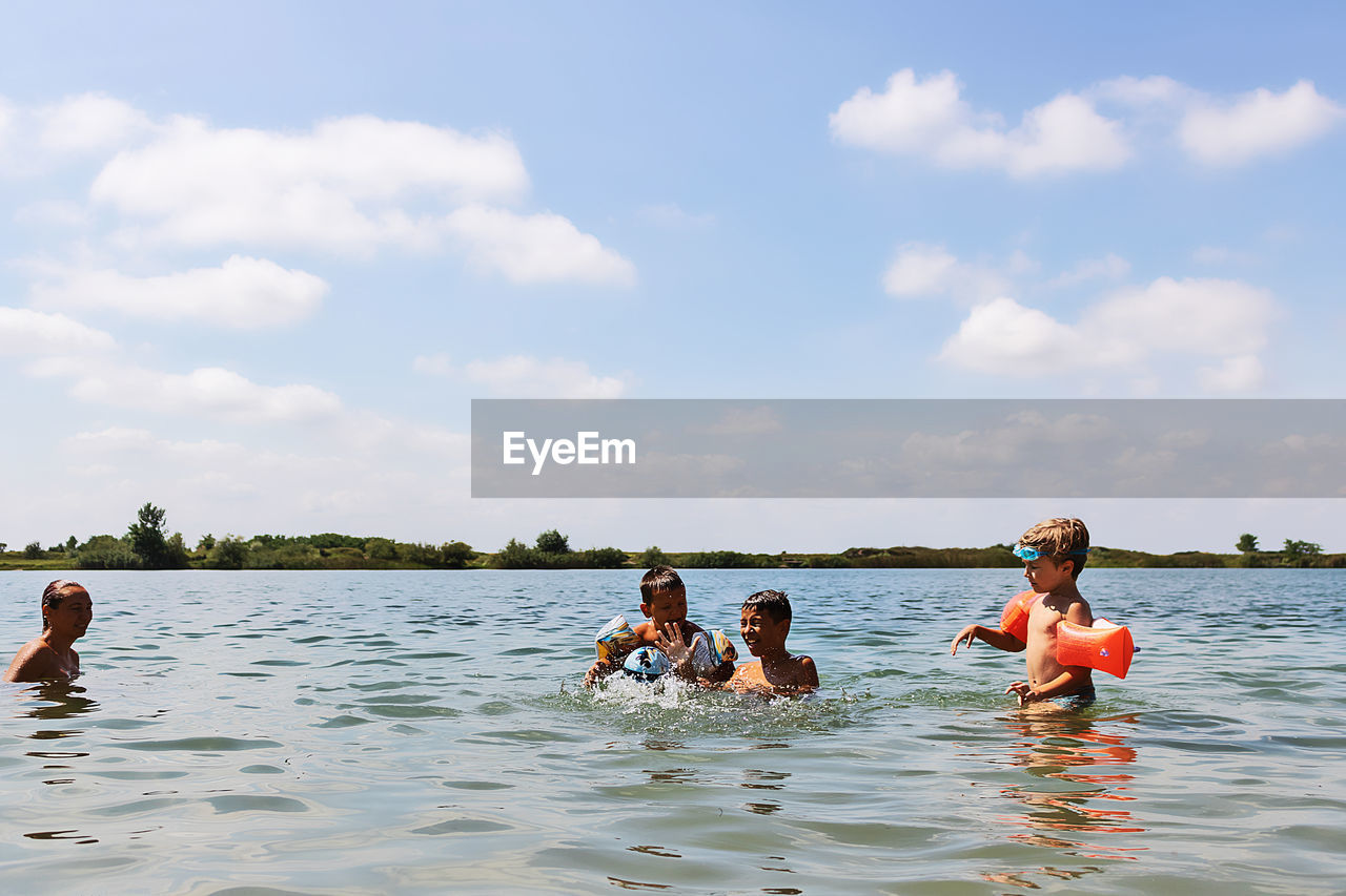 PEOPLE ENJOYING IN WATER AT PARK