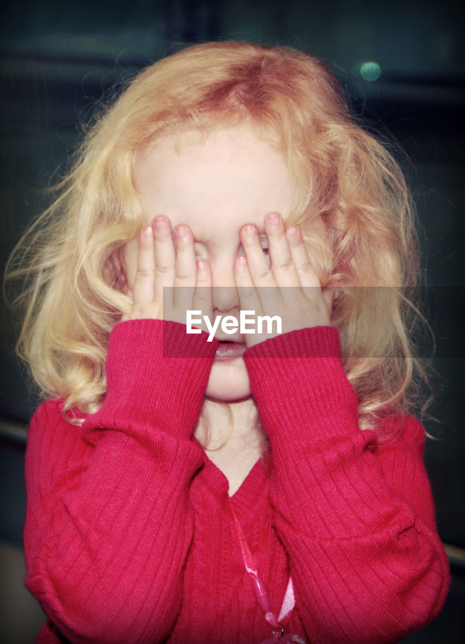 Cute girl hiding face with her hands