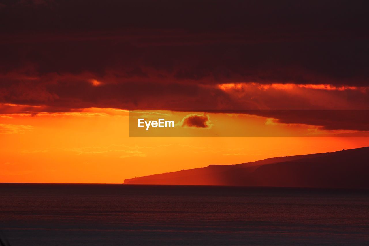 SCENIC VIEW OF SEA AGAINST ORANGE SKY