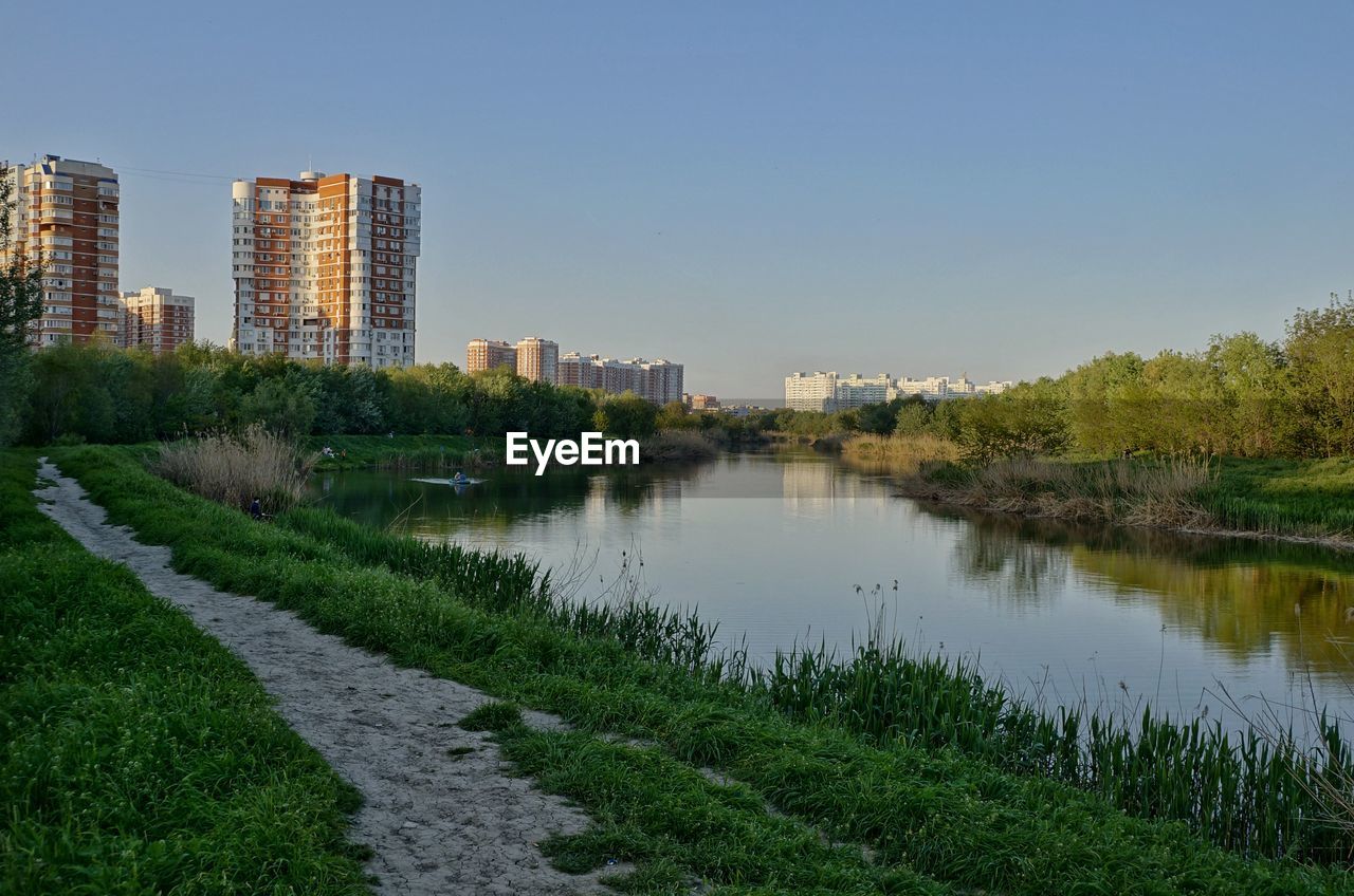 SCENIC VIEW OF LAKE AND BUILDINGS AGAINST SKY