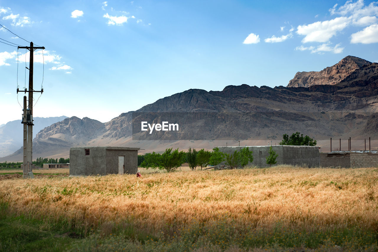 SCENIC VIEW OF FIELD AGAINST MOUNTAIN RANGE