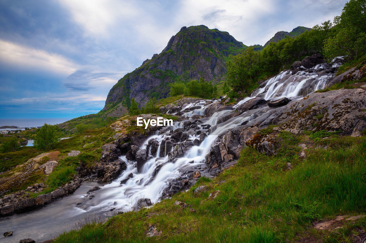 scenic view of river amidst mountains against sky