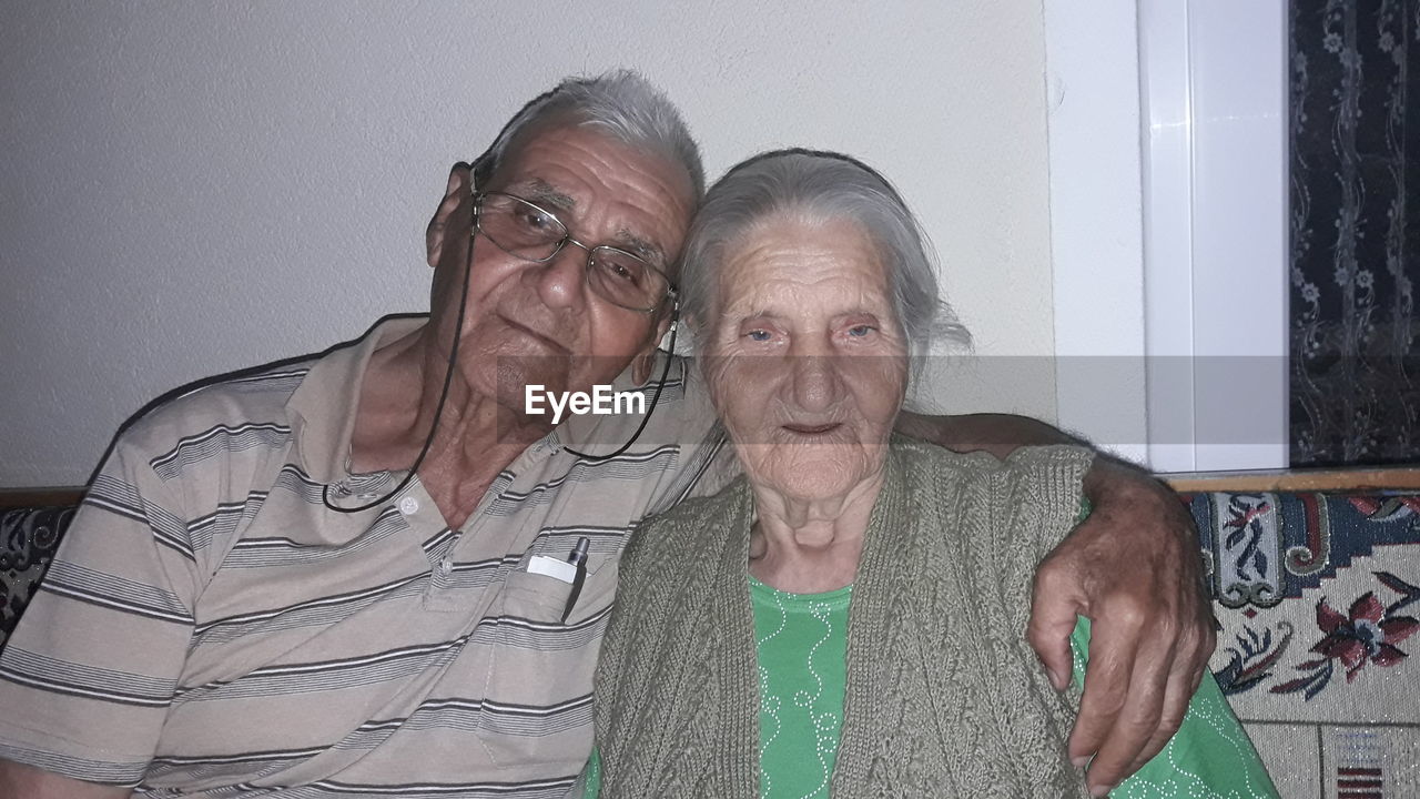 Portrait of senior couple with arms around