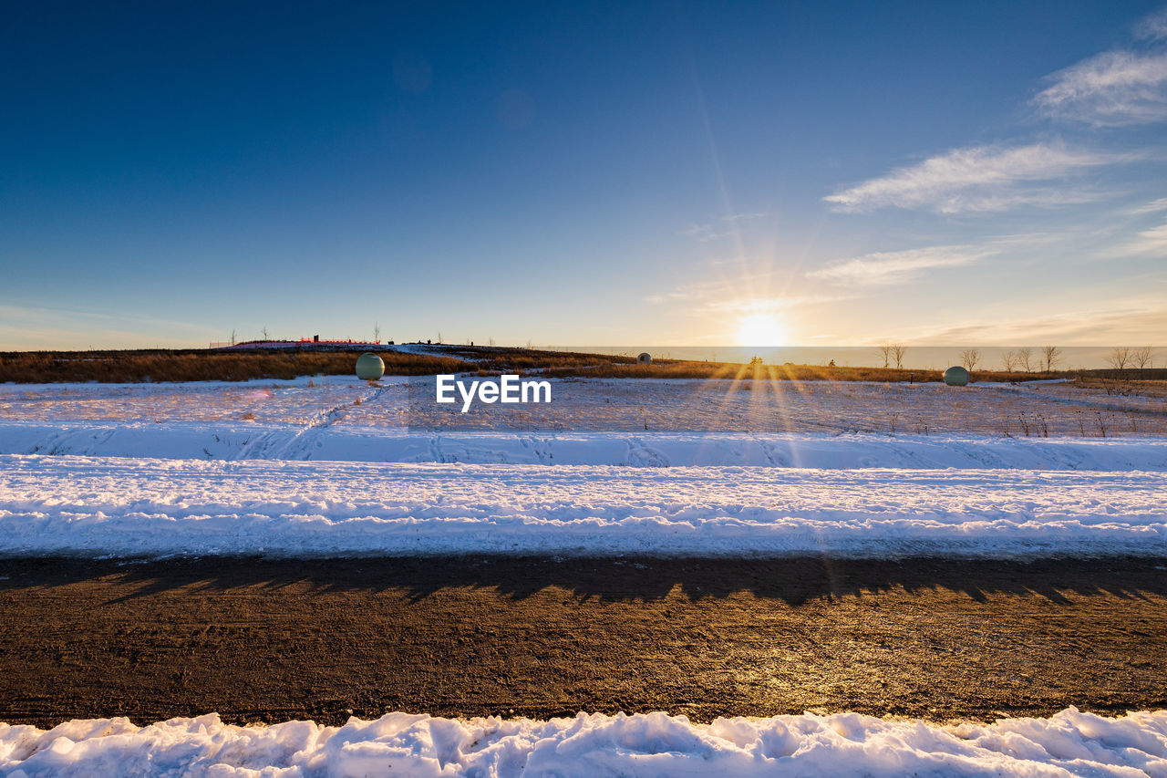 SCENIC VIEW OF SNOW COVERED FIELD AGAINST SKY DURING WINTER
