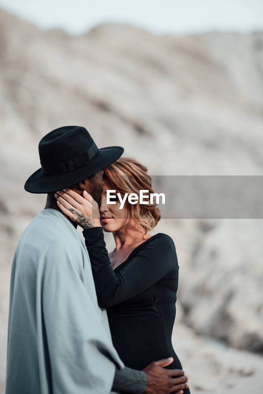 Couple embracing while standing at desert